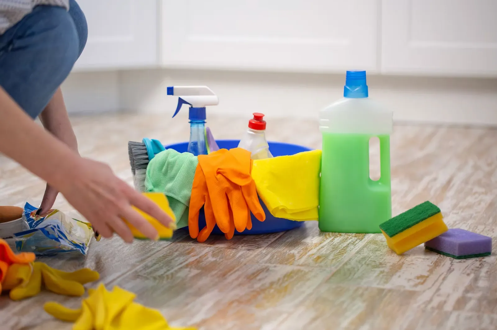 Productos de limpieza y desinfección: pulverizador, botellas, cubo, bayeta y estropajo
